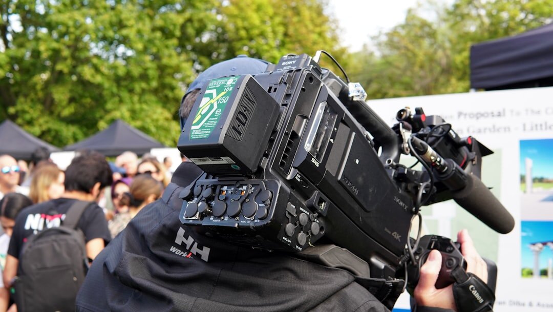 Camera operator on location shooting professional news footage outdoors